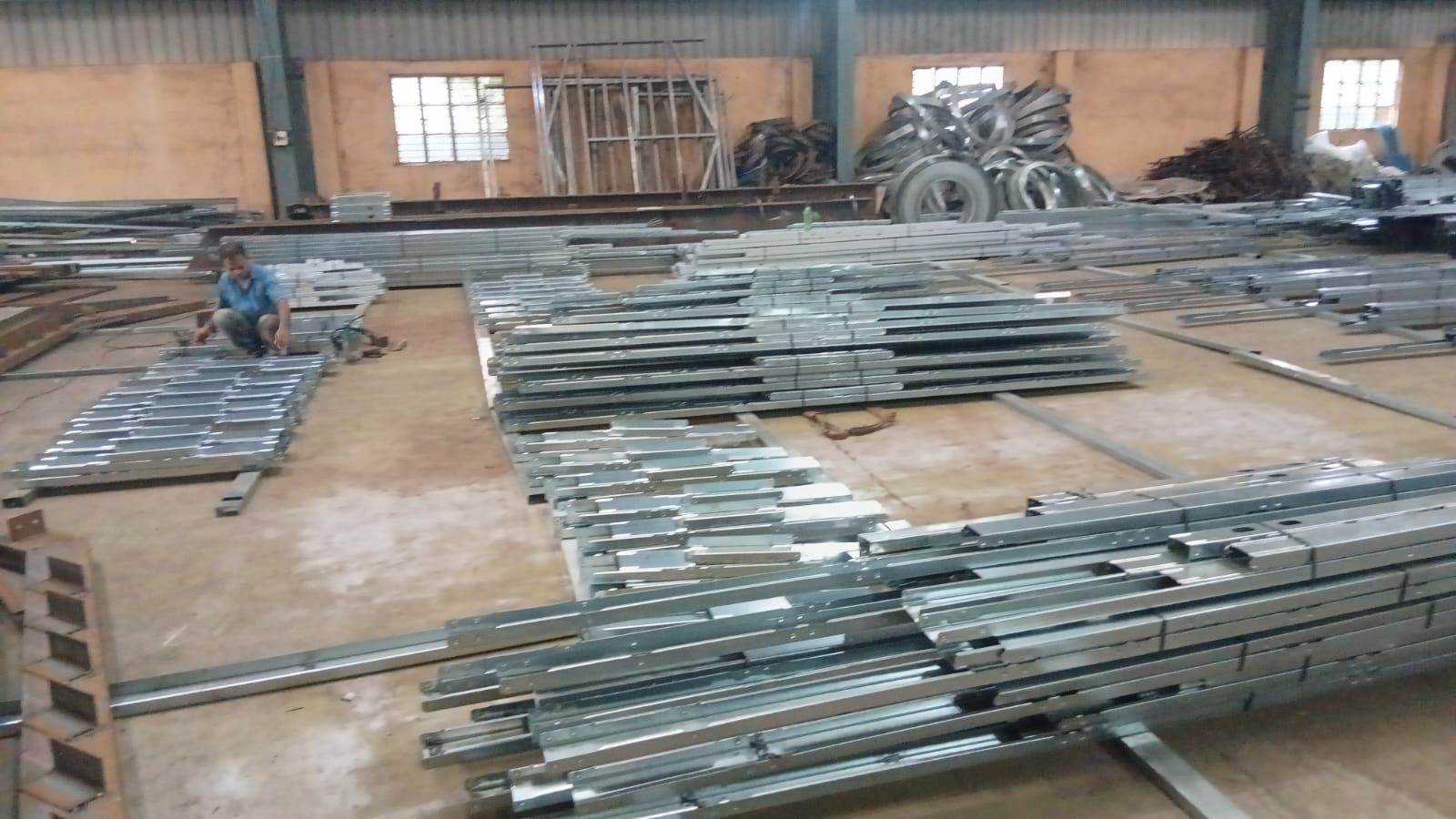Galvanised LGSF studs and tracks cut to length with service holes punched, laid out on the factory floor at Panchla, Howrah