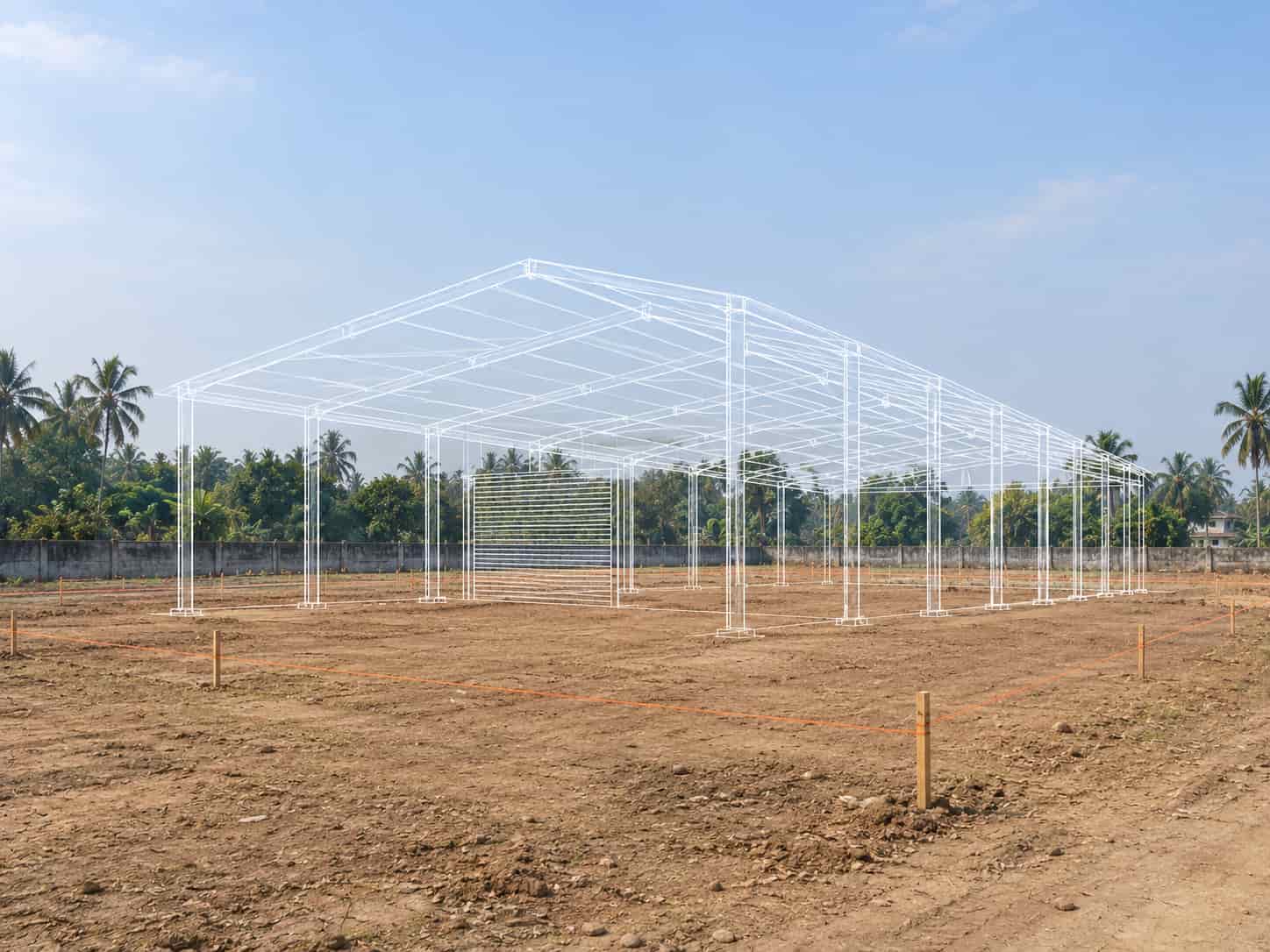 Empty industrial plot in India with a line drawing of the planned steel factory building