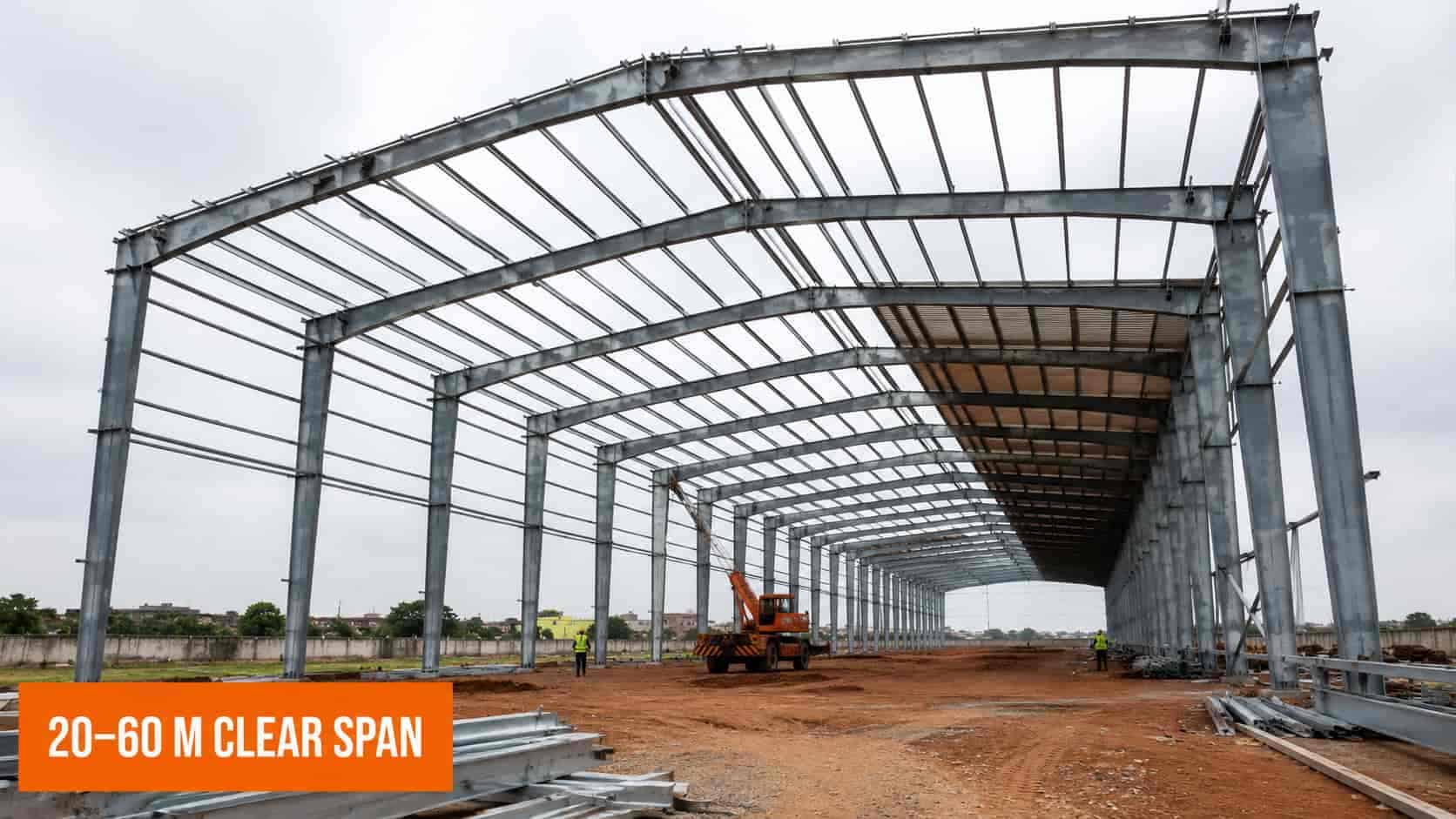 Industrial portal frame steel building under erection showing repeating tapered rafters and purlins
