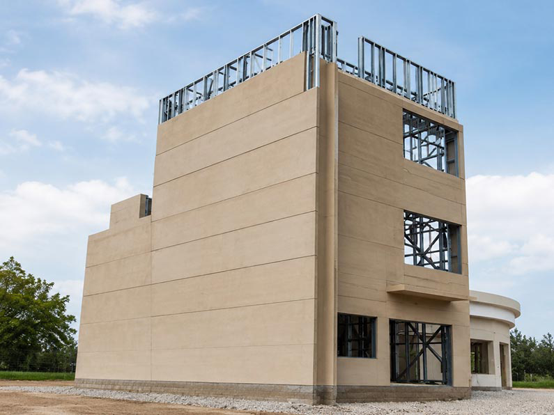 Multi-storey prefabricated steel bungalow with plastered facade and exposed roof-level steel framing