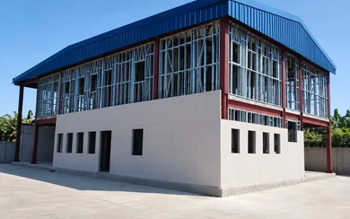 Two-storey hybrid steel fire station with blue pitched roof and glazed upper floor